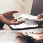 Entrepreneurs are receiving money that is a bribe of their partners with both of whom are corrupt in the company room.