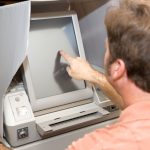 Man voting on a new touch screen machine in Florida.