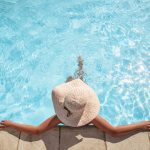 Young woman relaxing in the swimming pool with copy space
