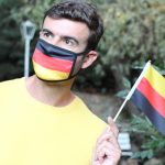 European man wearing coronavirus protective mask with german flag.