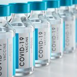 Row Covid-19 or Coronavirus vaccine flasks on white background
