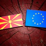 Macedonian flag with EU flag on a tree stump isolated