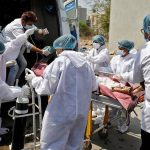 A patient is wheeled inside a COVID-19 hospital for treatment, in Ahmedabad