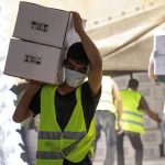 Workers carry boxes of humanitarian aid near Bab al-Hawa crossing at the Syrian-Turkish border, in Idlib governorate