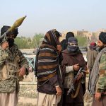 Members of the Taliban gather at the site of the execution of three men accused of murdering a couple during a robbery in Ghazni Province