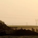 Turkish soldiers walk past a tank during a military exercise near the Turkish-Iraqi border in Silopi