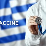 Close-up of a doctor and the word vaccine on the background of the flag of Greece. Corona virus vaccine production. Pandemic, isolation, 3rd wave, epidemics.
