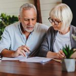 Mature couple with financial documents in home interior