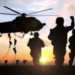 silhouette  of military operation at sunset with sun glare
