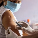 vaccine for covid-19 is being given to an Indian woman wearing nose mask