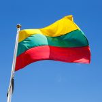 Lithuanian flag waving in thewind on a blue sky.