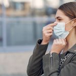 Woman in a mask stands on the street