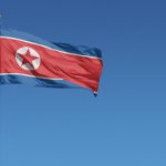 Flag of North Korea in front of a clear blue sky