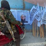 Members of Taliban forces gather and look at the picture of their leader Mullah Haibatullah Akhundzada, in Kabul