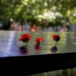 Flowers stand on names of victims on the south reflecting pool at the 9/11 Memorial site in the lower section of Manhattan, New York City