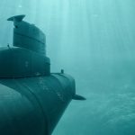 Ein U-Boot taucht im Meer durch klares Wasser.