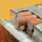 Pack of cigarettes on yellow background. Close up.