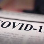 COVID-19 written newspaper close up shot to the text.