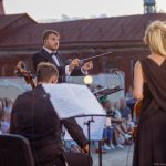 Conductor directing orchestra performance on the street